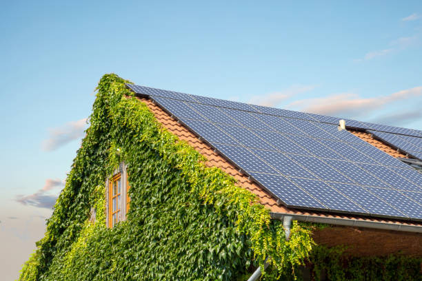 house roof with solar panels against a blue sunny sky Sustainable Roofing